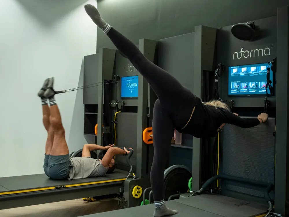 Two members training on Nuforma reformers at the Surrey Quays studio.